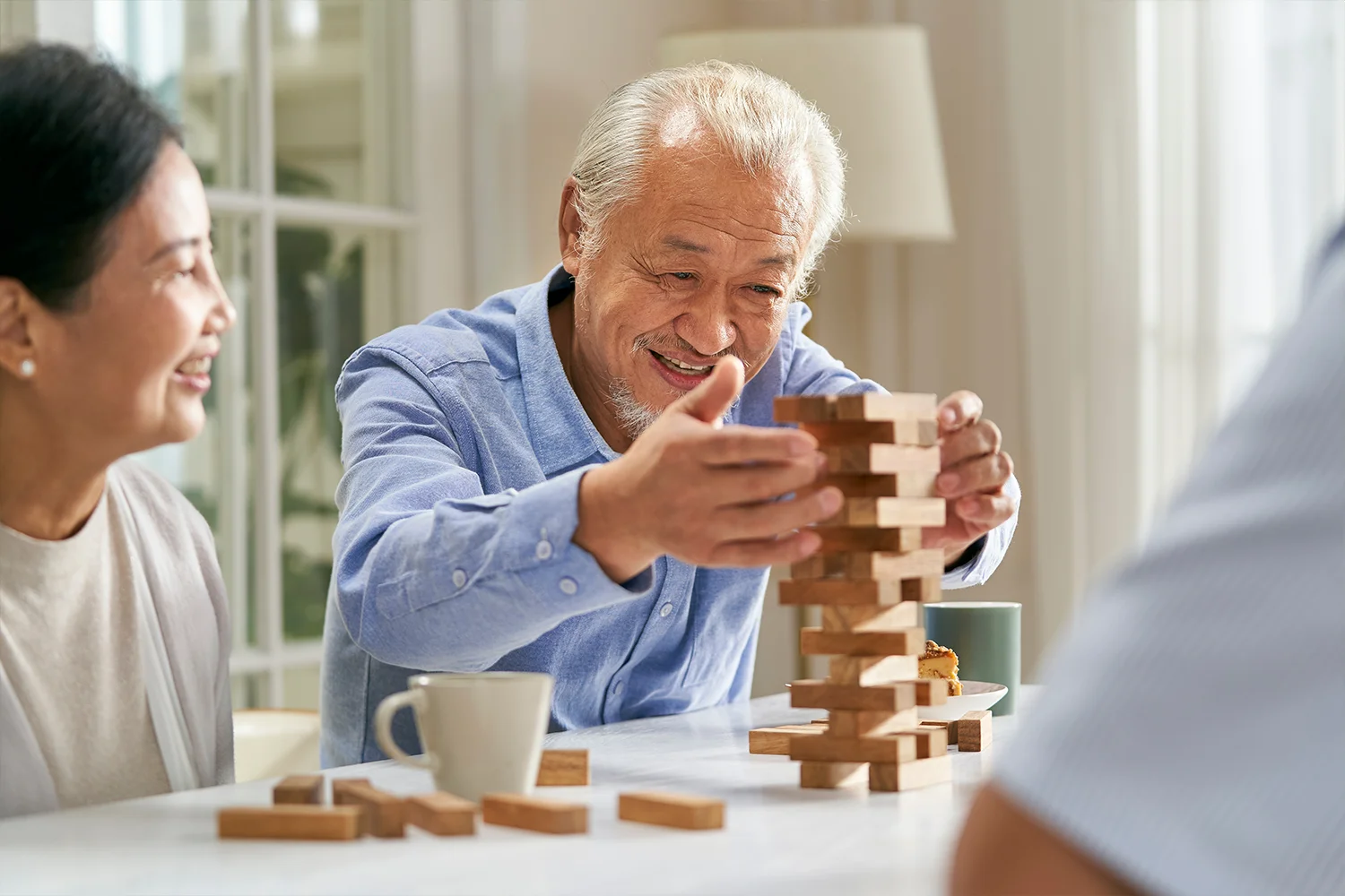 Older adults enjoying a tabletop block game together at home