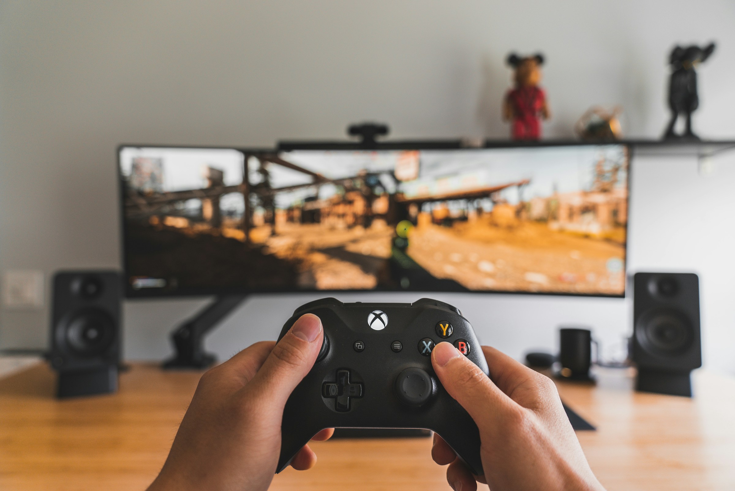A player using a controller in front of a gaming monitor